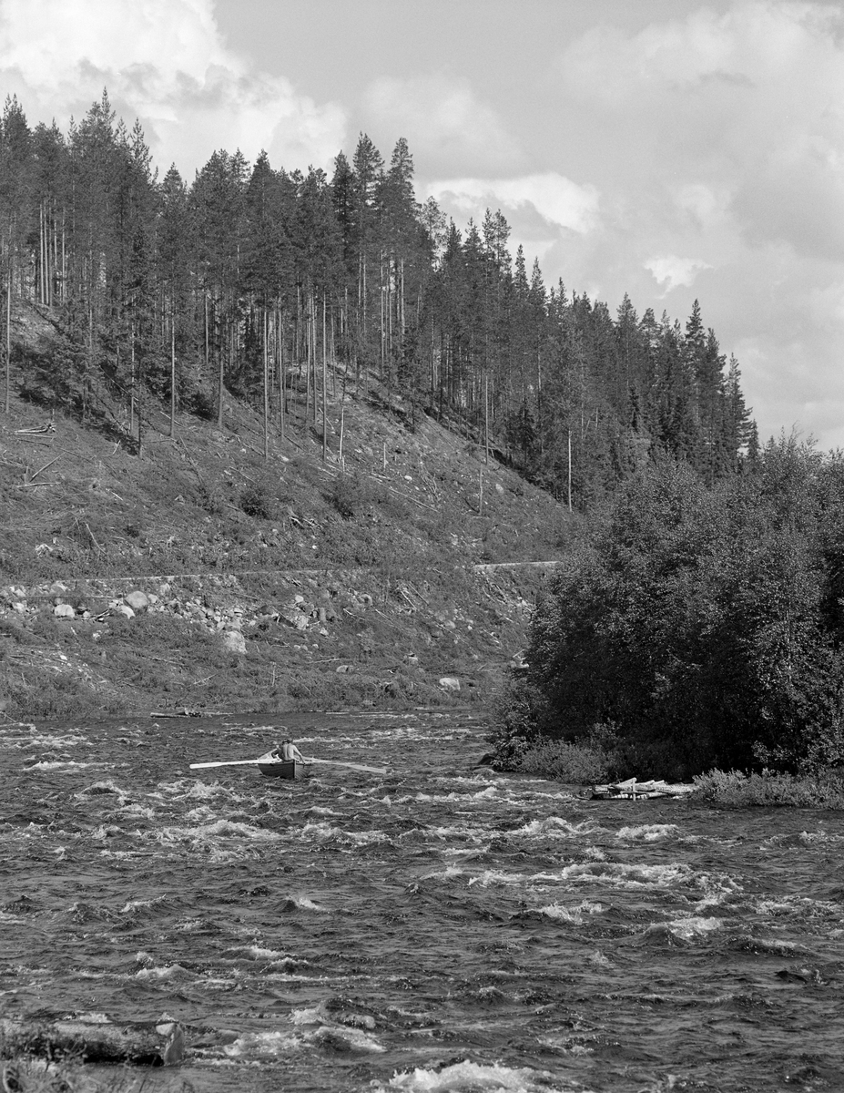Sluttrensk i elva Stor-Grøna i Trysil, Hedmark. Fløtere på veg ned elva i robåt.