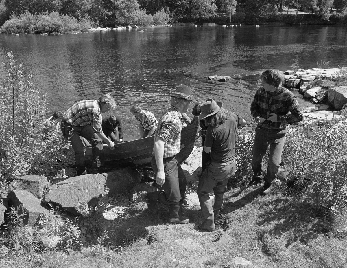 Robåt frakters over land på Prestøya i forbindelse med fløting, fra Klokkerfossen til Prestfossen i Glomma. Skogbruksmuset (nå Norsk skogmuseum), Elverum, Hedmark.