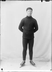 Portrett av mann med lue stående på skøyter