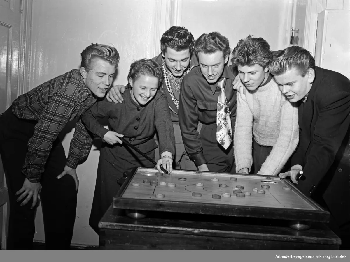 Medlemmer av Sagene og Ila AUL innvier sitt nye hobbyrom. Formannen i laget, Inger Halvorsen, omgitt av (fra venstre) Bjørn Hågensen, Tore Gårder, Frank Hansen, Jan Andersen og Knut Kristensen. Desember 1953.