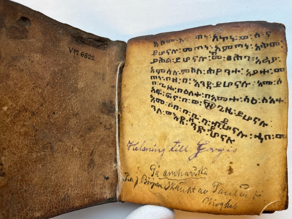 Amharisk bönbok. Textat med svart och rött på pergament. Läderpärmar.