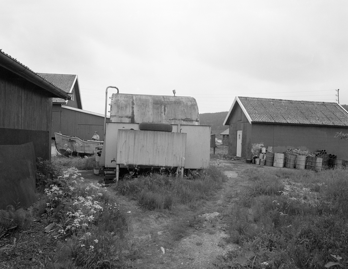 Driftsbygning ved Furuholmen, Varteig, Østfold. Brukt i forbindelse med tømmerfløting i Glommavassdraget. Lager, verksted, tank, varpebåt, div. tønner.