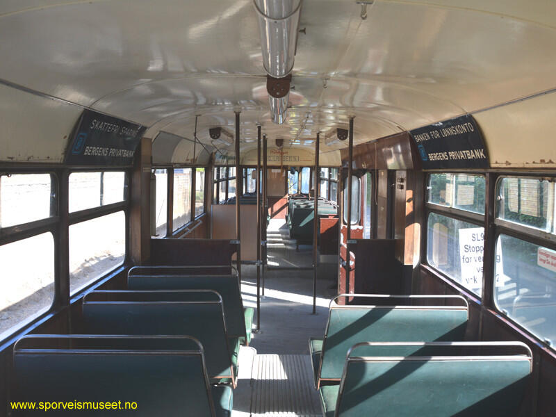 Forstadsbane/sporvogn fra 1950-tallet med rød farge på nedre halvdel og en lys grå farge for øvre del. Interiøret består av doble seter i en blågrønn farge med brune vegger og reklame hengende mellom vindu og tak. 