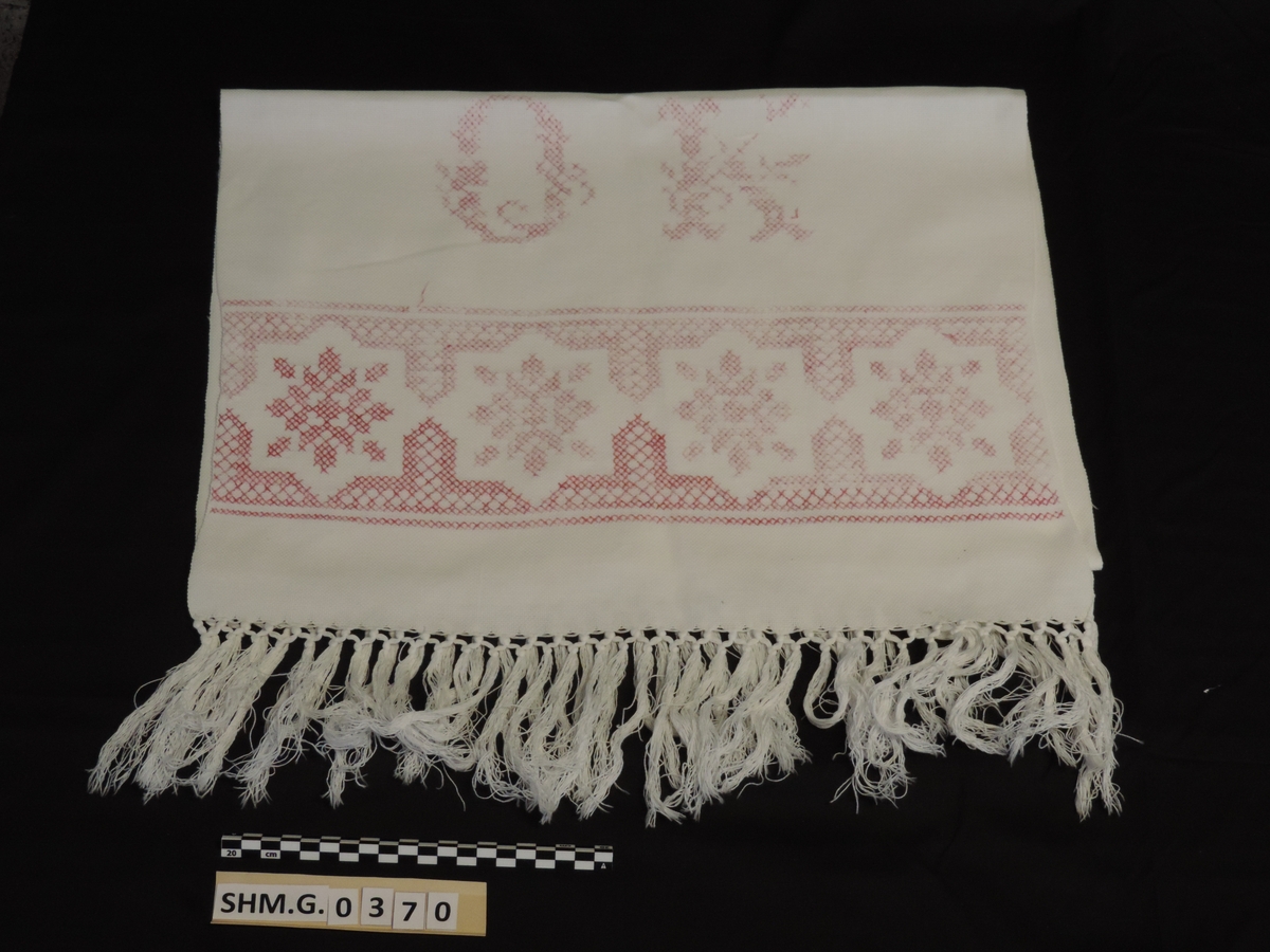 Pyntehåndkle i hvit sultan med knytte frynser og korsstingsbroderi i rødt D.M.C garn. Monogram O.K
