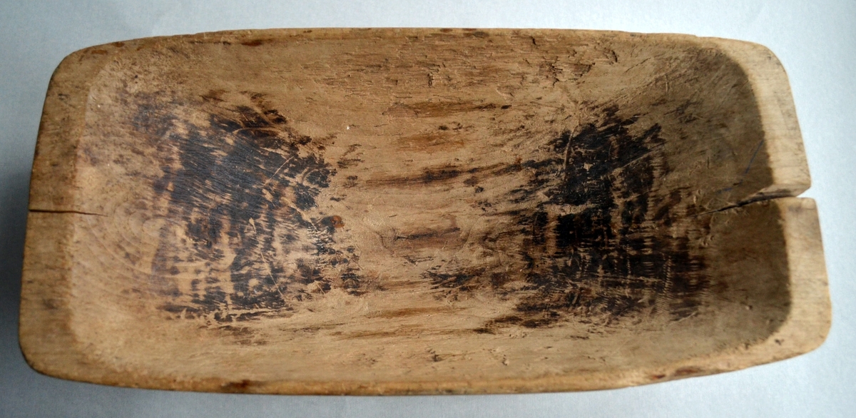 Litet tråg tillverkat i trä, träslag okänt. Tråget är märkt på sidan med siffrorna 16 och sedan troligen ett bomärke som ser ut som 17. Under tråget finns inskriptionen + 11 /8 1854 + som förmodligen är tillverkningsdatum. Tråget är i gott skick men har två sprickor i kortsidorna. Inuti är tråget delvis mörkbrunt, troligen en missfärgning från det som förvarats i tråget.