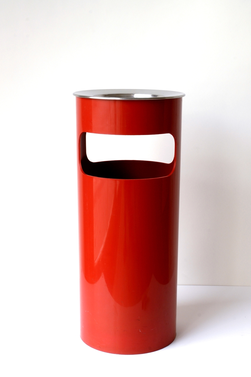 Röd papperskorg med öppningar från två sidor för att slänga skräpet. Tillhörande skålformat lock i metall fungerar som askfat.
