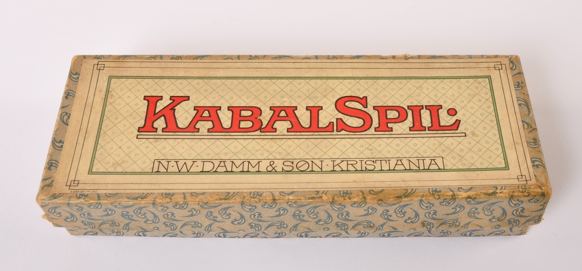 Kabalspill med små kvadratiske pappbrikker med påtrykte nummer, i original eske med teksten: KABALSPIL. NW DAMM & SØN KRISTIANIA