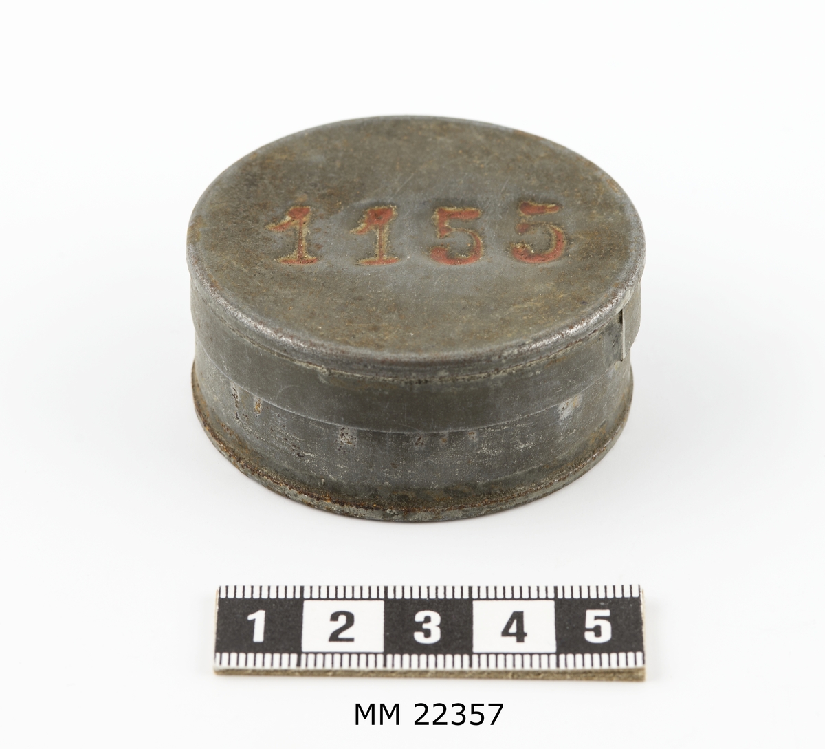 Avlöningsask av bleckplåt, rund med lock.
Märkt på locket: "1155".
Jämför K 9512.