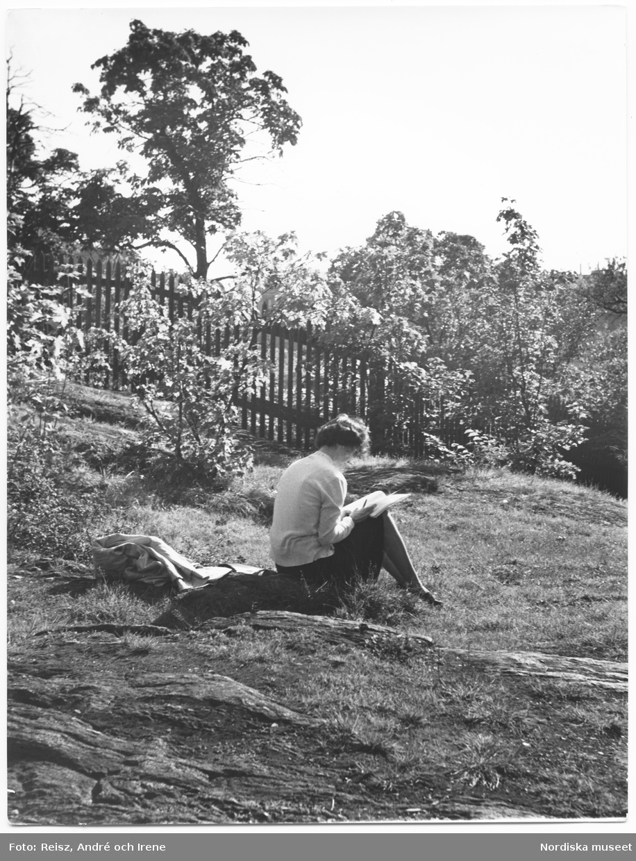 Stockholm. En kvinna läser en bok i naturen.