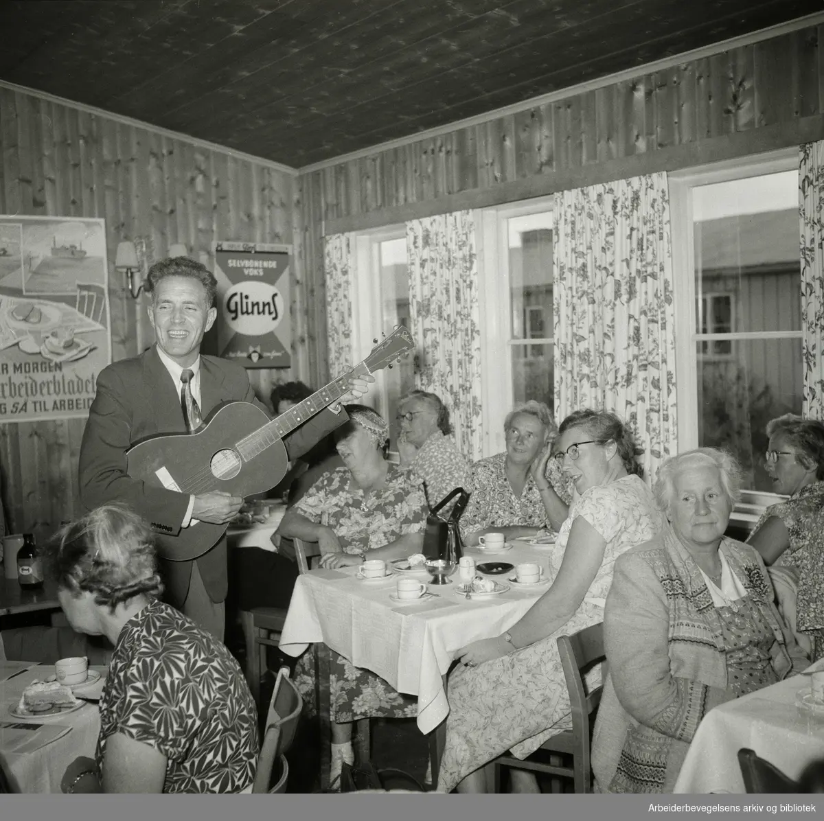 Arbeiderbladets husmortimer på Helsfyr hotel i Oslo. Tryggve Aakervik (1917-2006) "Mannen med den røde gitar" synger og spiller. September 1955.