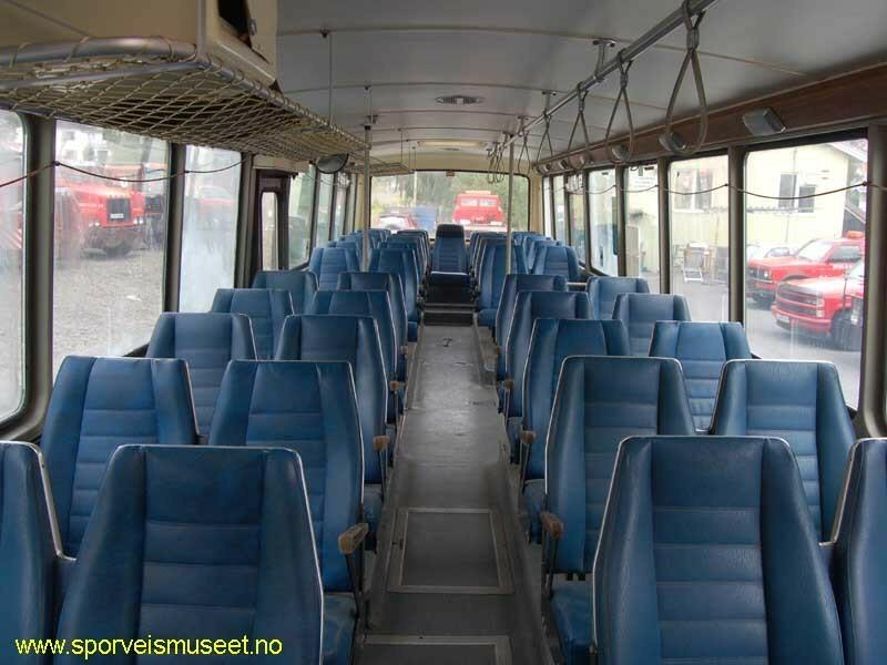 Buss med rød farge i nedre halvdel, et grått bånd som går rundt bussen og en hvit farge som går rundt vinduene og dekker hele taket. Bussen har to enkle dører, en ved sjåfør og en ved bakre hjul. Interiøret består av et mørk grått gulv, lyst tak og blå seter. 