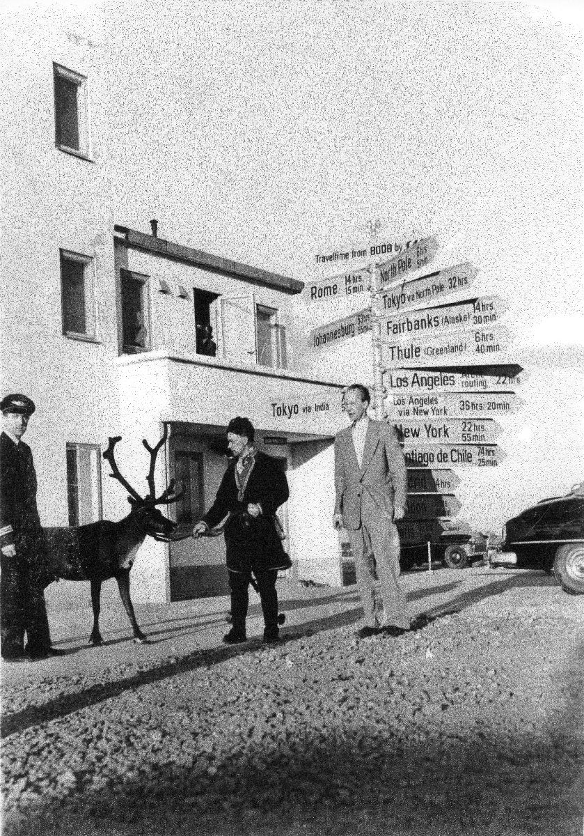 Tre menn og et reinsdyr oppstilt foran veiviseren på Bodø flyplass.