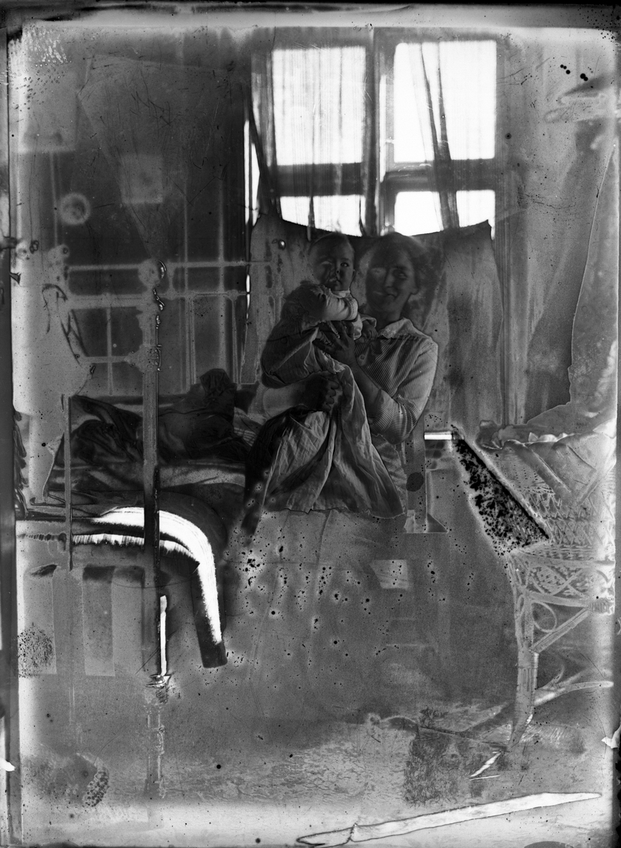 Fotosamling etter Kjetil Skomdal (1881-1971). Fotografen virket i perioden 1910 til 1960 og hadde eget mørkerom hvor han også tok imot film fra andre fotografer. I perioden var han også postbud i Fyresdal. Portrett av kvinne med barn.