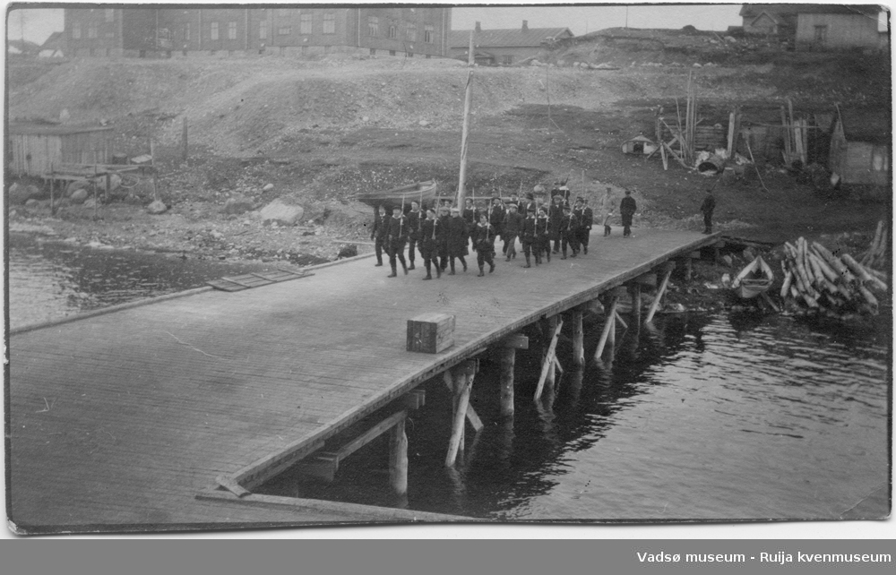 Gaster som marsjerer på kai i Kirkenes havn. Bildet har tilhørt Lars Rygh fra Hønefoss, som var på med på mineryddingsoppdrag i Varangerfjorden 1917 -1918.