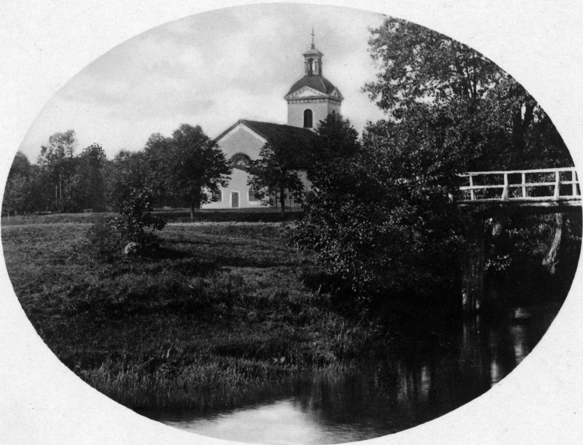 Landskyrkan som skymtar bakom träden vid Säveån.