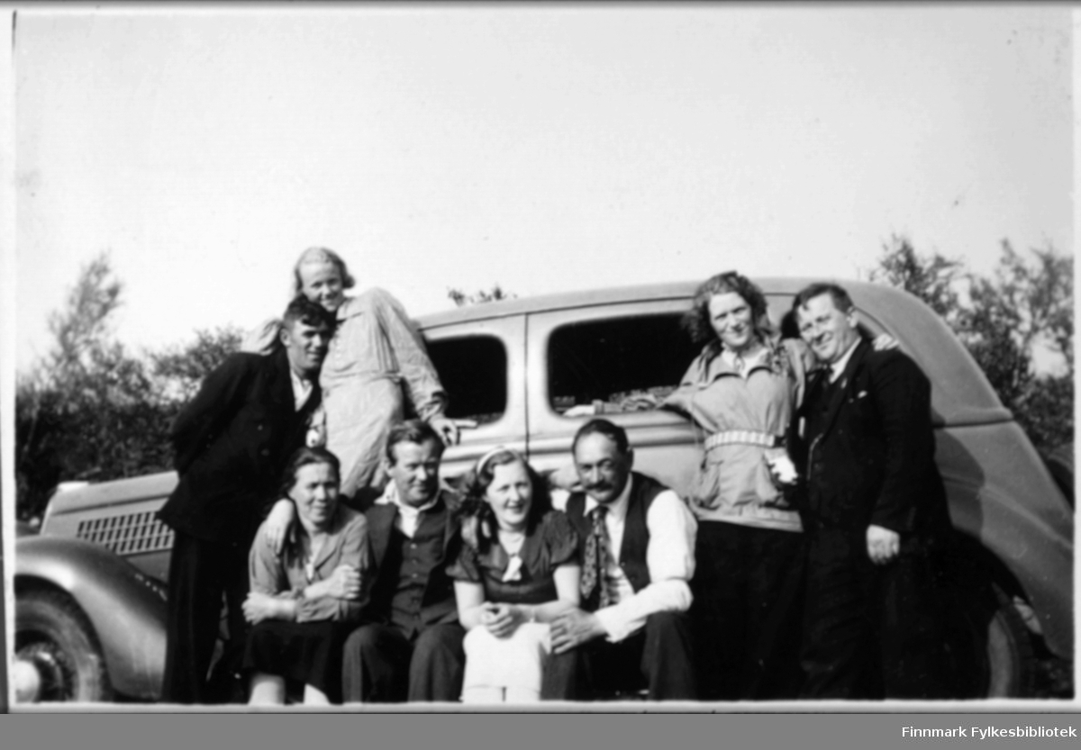 Kvinner og menn foran en bil (Ford V8 årsmodell 1935). Stedet er antakelig i Karasjok.