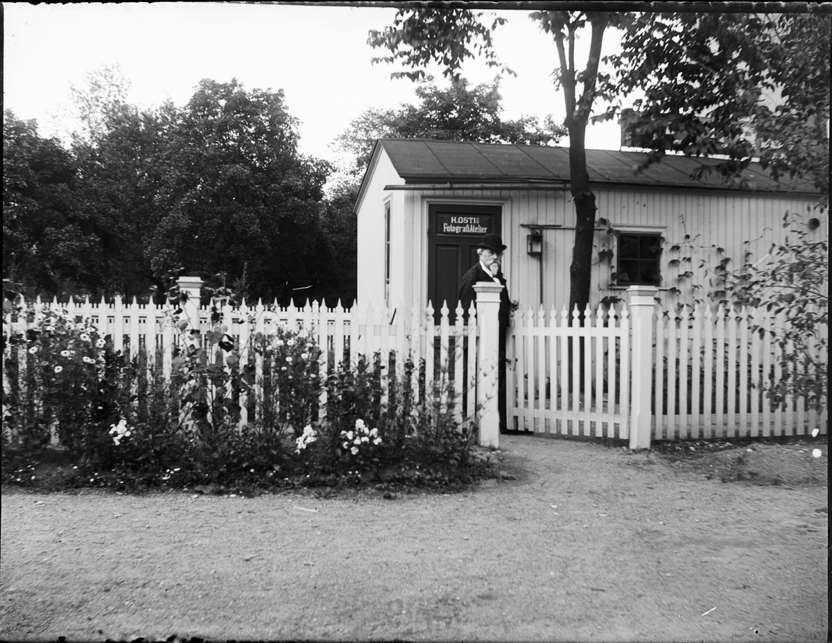 Henri Osti vid grinden utanför sin ateljé, Bredgränd 11, Uppsala