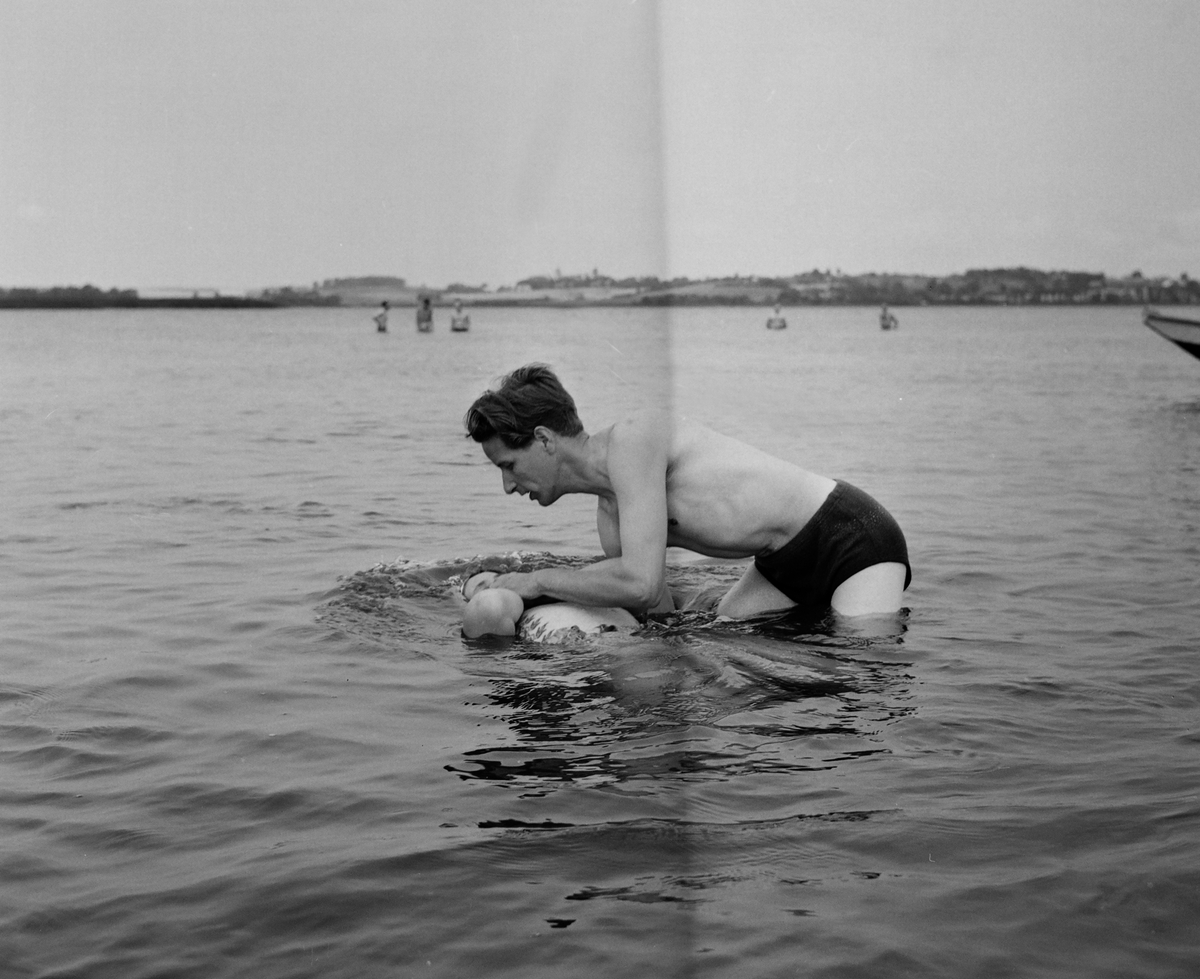 Dop av Jehovas Vittnen i sjön Roxen, Linköping, 1957.
Pressfotografier från 1950-1960-talet. Samtliga bilder är tagna i Östergötland, de flesta i Linköping.