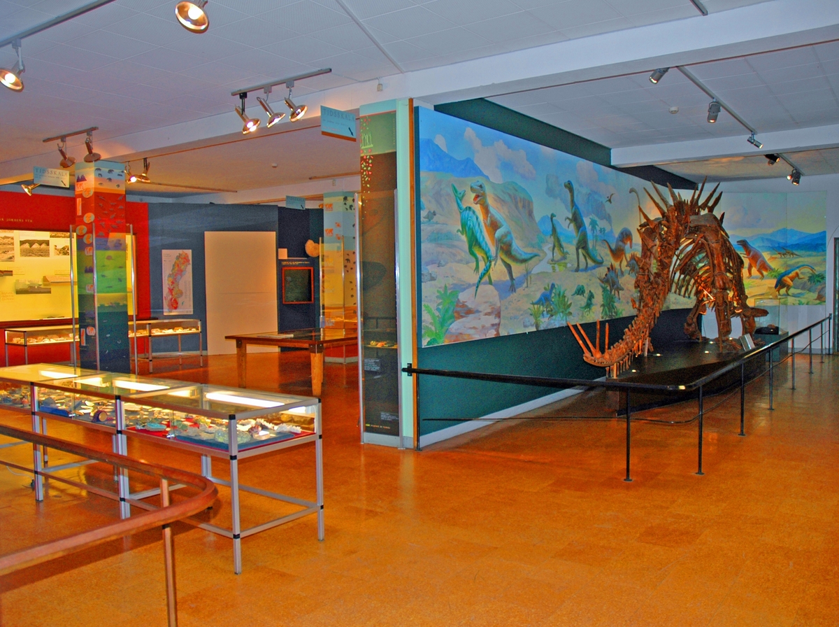 Utställningen Vår Jord, öppnade ca 1973 och stängdes 2014.
Bild på dinosaurien med målningen i bakgrunden.