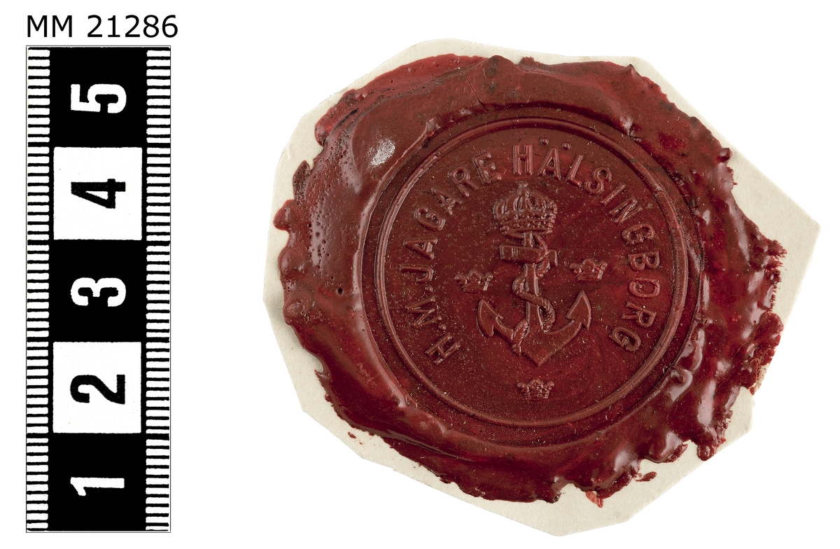 Sigillavtryck av rött lack på papper. I mitten krönt stockankare omgivet av tre kronor. Längs kanten text: "H.M. Jagare Hälsingborg".