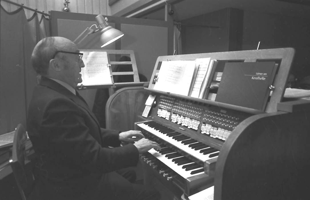 Oddmund Lorentzen på orgelkrakken, med mannskoret Ljom. 