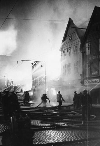 Bildet viser brannen på Bryggen i 1955 og brannvesenet som prøver å slukke.