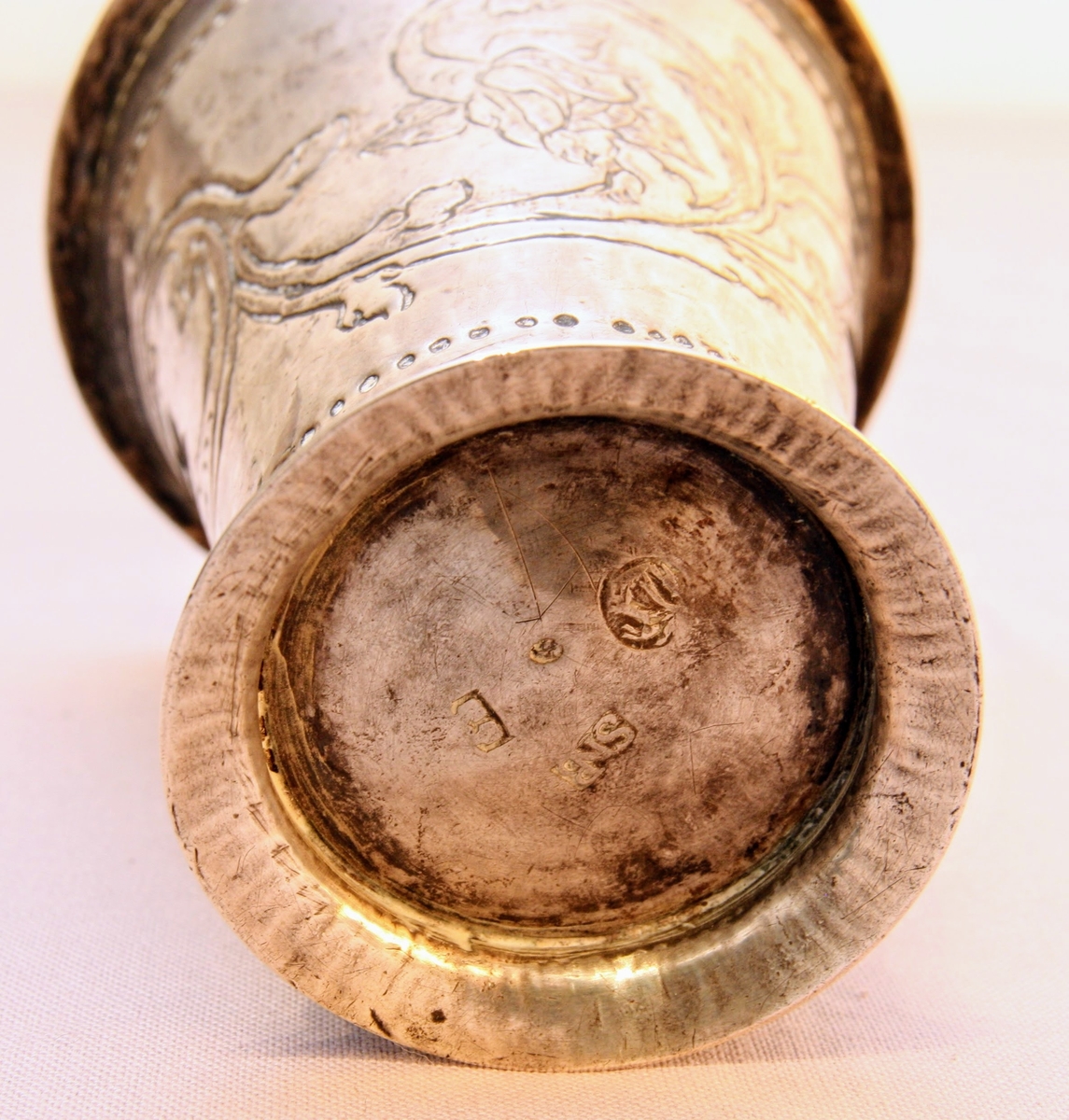 Bägare av silver tillverkad av guldsmed Sven Pettersson Nyberg, Varberg. Med etsad dekor föreställande rocailler/akantusblad och pärlstavar. Från år 1763. Stämplar i botten.