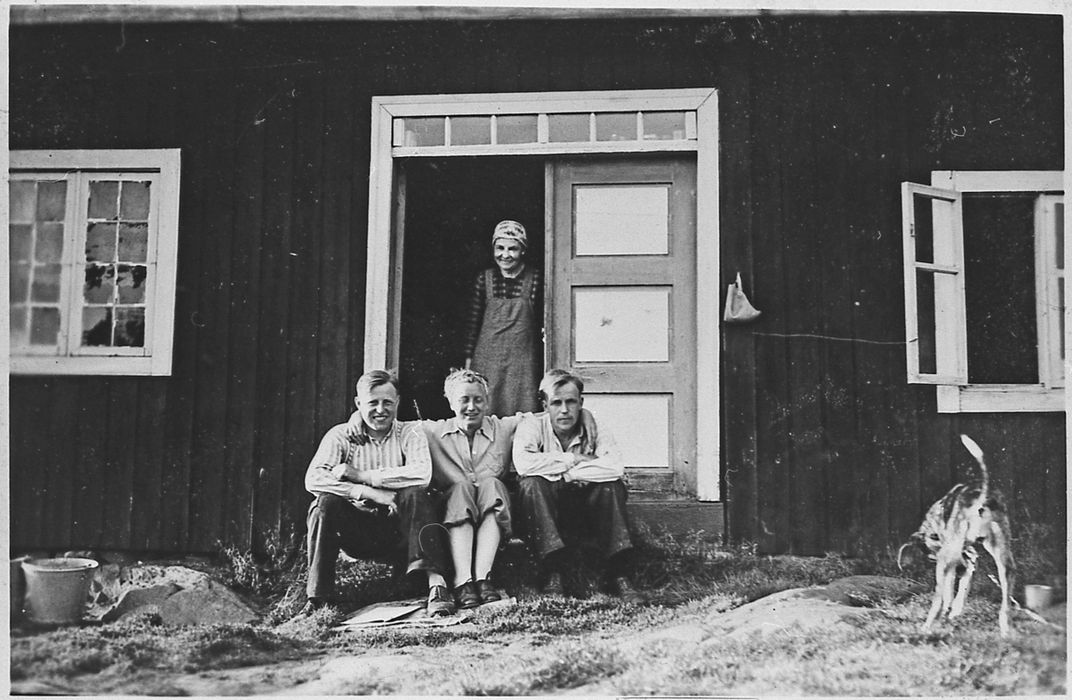 På trammen i Vasslien, ca. 1940. Foran fra venstre: Ole Flågan, Solveig Flågan, Anders Flågan og hunden Stella. I døra: Olava Flågan.