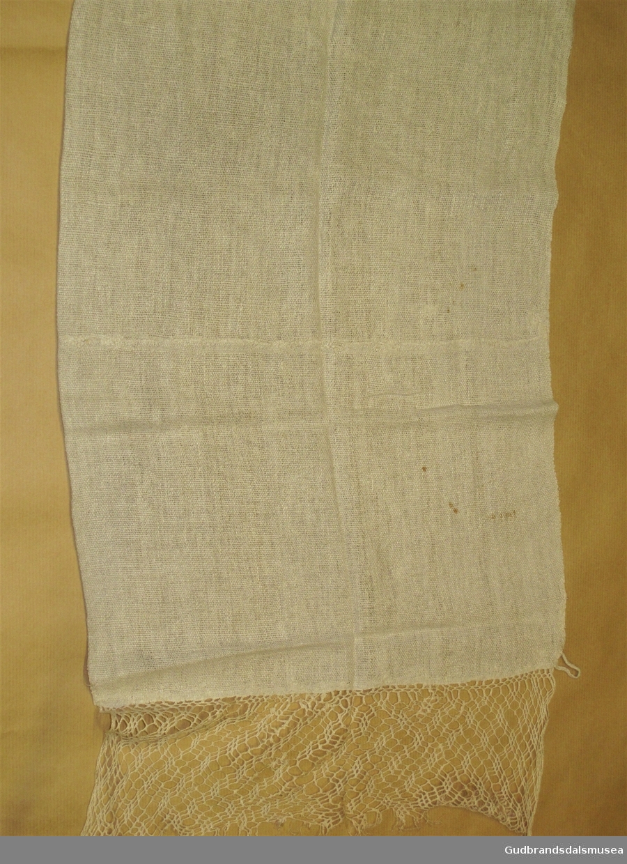 Kort, bredt og grovvevd pyntehåndkle. 15 cm lang, heklet border i ene enden.