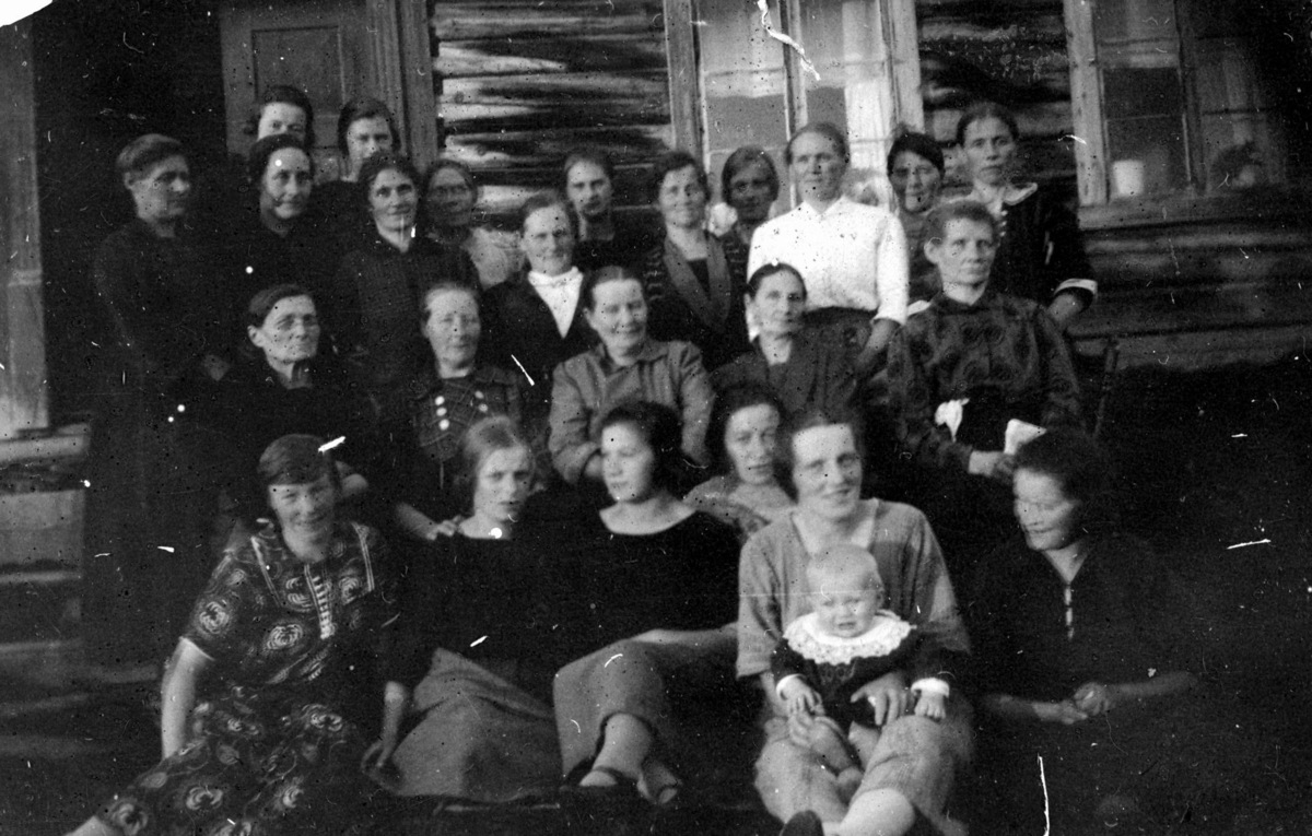 Gruppe med kvinner og et barn fotografert utenfor stua. Sannsynlig gården Helberg i Maukdalen i 1925.