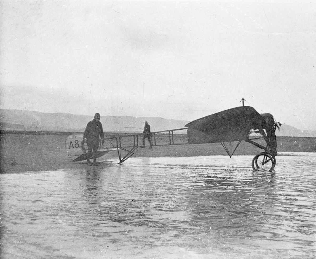 Flygplan Thulin A nummer 8 har rullat ut i en vattenpöl med issörja, omkring 1916-1919.