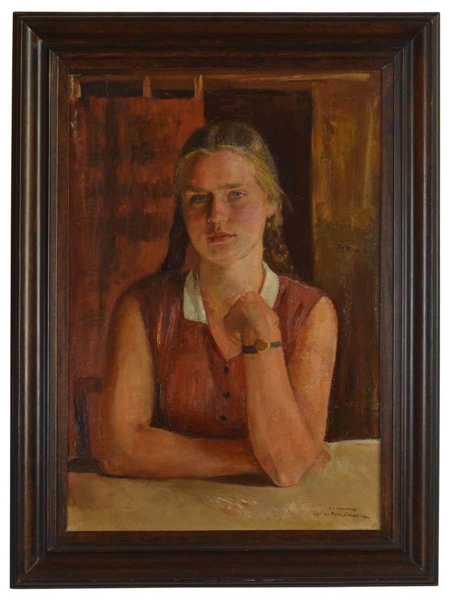 Susanna Lennerthson (1915-1998, gift Fritzsche) som 15-16-åring sittande vid bord i brun ärmlös blus, flätor och synligt armbandsur på armen som hon håller upp framför sig med stöd i bordet.