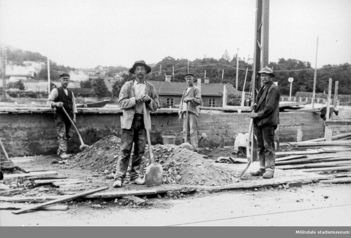 Spårvagnshallarna anläggs, 1920-tal. Fyra män poserar med spadar i händerna. De är med vid anläggningen av Spårvagnshallarna som låg i hörnet mellan Kvarnbygatan och Göteborgsvägen.