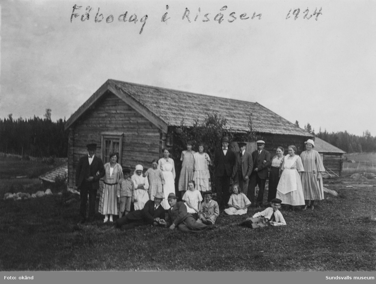 Fäbodag i Risåsen, Stöde, 1924. Gruppbild med vuxna och barn invid en timrad fäbodstuga. Ur en samling som tillhört Olof Mattsson, Gräfte, Stöde.