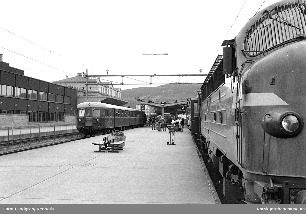 Lokaltog fra Støren med dieselmotorvognsett type 86 og persontog til Stockholm trukket av diesellokomotiv Di 3 630 på Trondheim stasjon