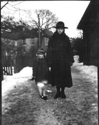 Biørn - kvinne og pike i hatt og kåpe  i gata med  Buchholmg