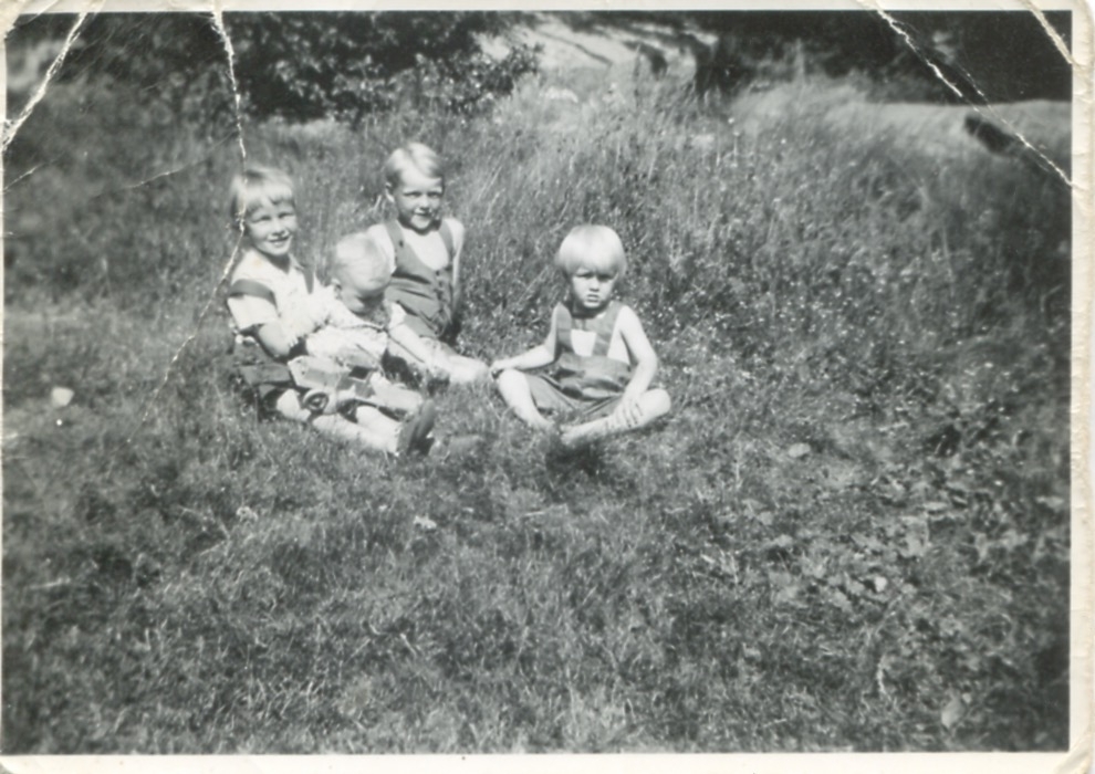 Fyra små barn sitter på en gräsmatta i Vommedal cirka 1941. Från vänster: Kerstin Waldt Gullberg. 2. Gunnar Waldt (1940-2002). 3. Olle Svensson (född 1934). 4. Olle Waldt (1937-1987).