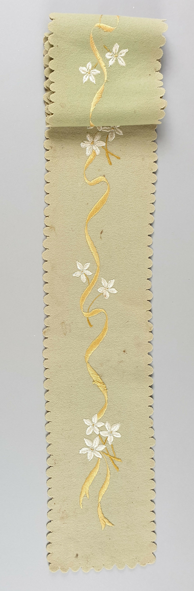 To grrønne løpere av filt, med brodert blomstermotiv i hvitt og gull.
Det ene smalere enn det andre, og med enklere blomstermotiv.