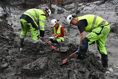 Arkeologene Lars Bigum Kvernberg, Christian Rodum og Linn Cecilie Hobberstad graver frem en metallgjenstand på tomt B8b i Bjørvika. Foto/Photo