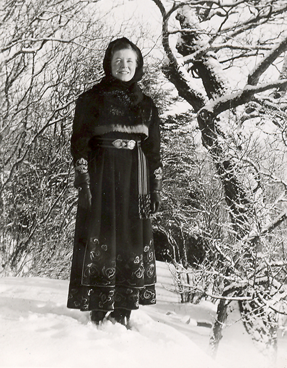 Ung kvinne i ein vinterkledd hage på Bø prestegard.