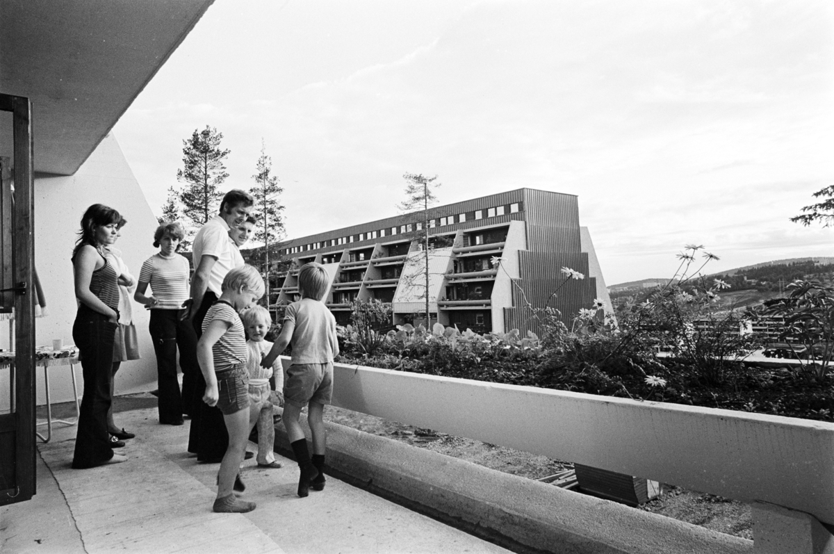 Voksne og barn står på terrasse på Vestlifeltet.