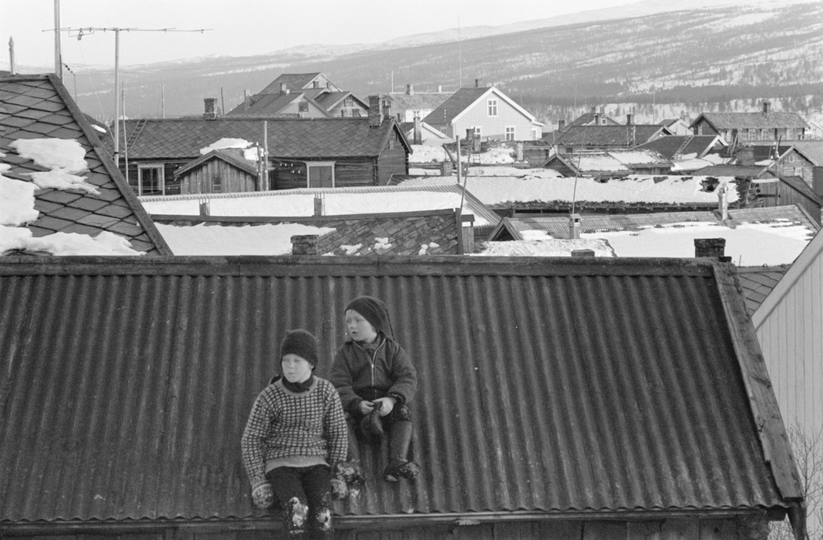 Barn leker i et snødekt bylandskap på Røros.