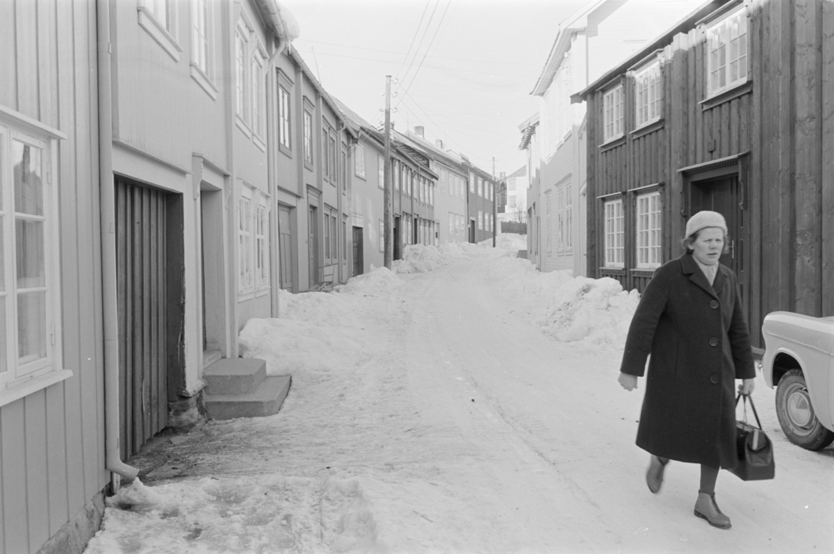 En kvinne går i en gate på Røros.