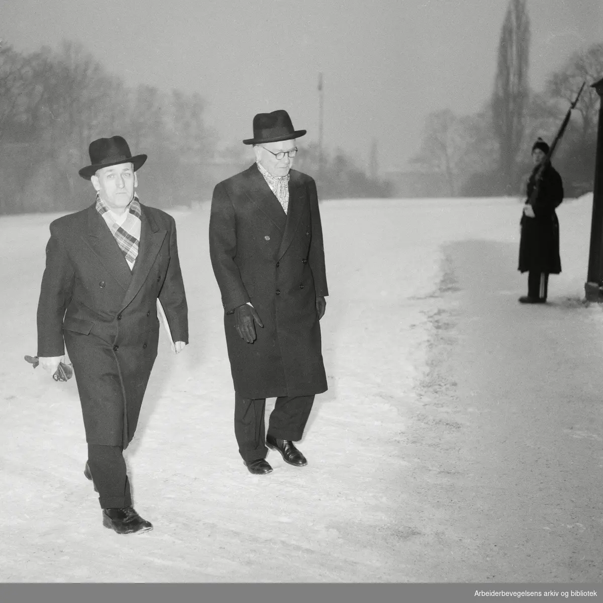 Regjeringen Oscar Torp går av. Avskjedssøknaden ble innvilget av kong Haakon VII i statsråd 21. Januar 1955. Fiskeriminister Peder Holt og kirke- og undervisningsminister Birger Bergersen ankommer slottet.
