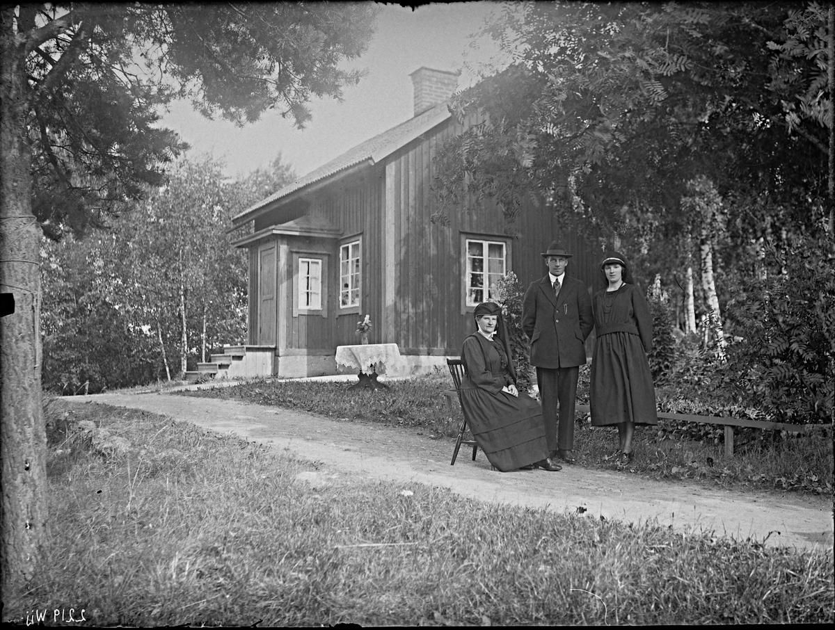 Fotografering beställd av Danielsson. Föreställer sannolikt änkan Anna Lovisa Asp (1879-1950) med dottern Sanna Lovisa (1904-1987). De är sorgklädda efter familjefadern Anders Gustaf Danielsson som avled den 23 juli 1923. Mannen är ej identifierad.