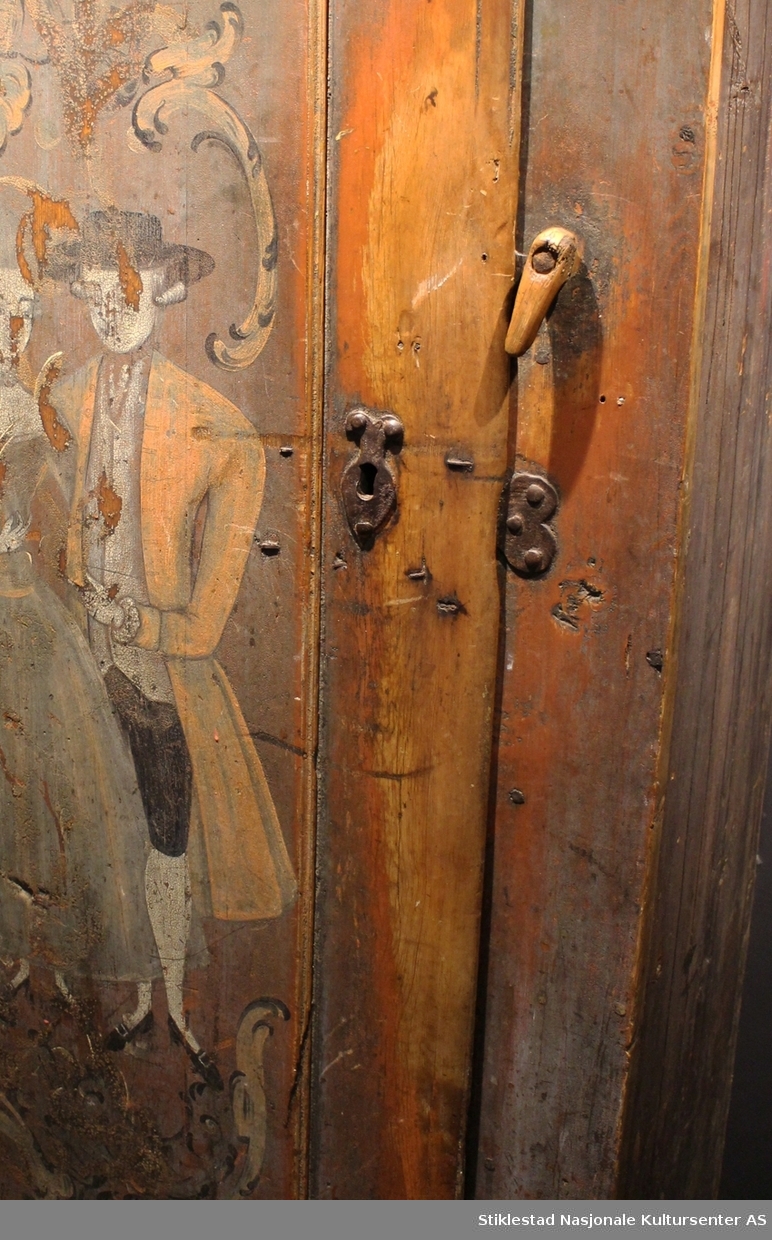 Matskapet dekorert med rosemaling og figurmaling av «rokokkomaleren» Ole Haldosen Berg (1747-1828). 
Gesimsen øverst på sideveggene er fjernet, og spikrene på hengslene er skiftet ut, ellers er skapet intakt med originale beslag (festet på nytt?). Motivet på døra viser et par i finstasen med rokokkoranker rundt. Øverst på døra står bokstavene TES.MJD. Over døra står årstallet 1755, men dette er overskrevet med bokstavene N.O.S.M..E.T.D.M og årstallet 1789. Vi antar at S og D i begge tekstene står for sønn og datter, og at dette er initialene til eierparene, som har skiftet i 1789.
Skapet har en del slitasje på høyre side av døra, ved låsen, etter åpning og lukking av skapet. Etter høyden på disse slitesporene å dømme, har også de minste vært inne i matskapet en del i løpet av årene. Helt nederst vises også hull etter mus som har gnagd seg inn på jakt etter mat. Baksiden av skapet er grovt tilvirket, her vises tydelige spor etter bearbeiding med både øks og pjål/skjøve. Innvendig har skapet tre hyller, mangler nøkkel. Skapet er malt av Ole Haldosen Berg (1747-1828).