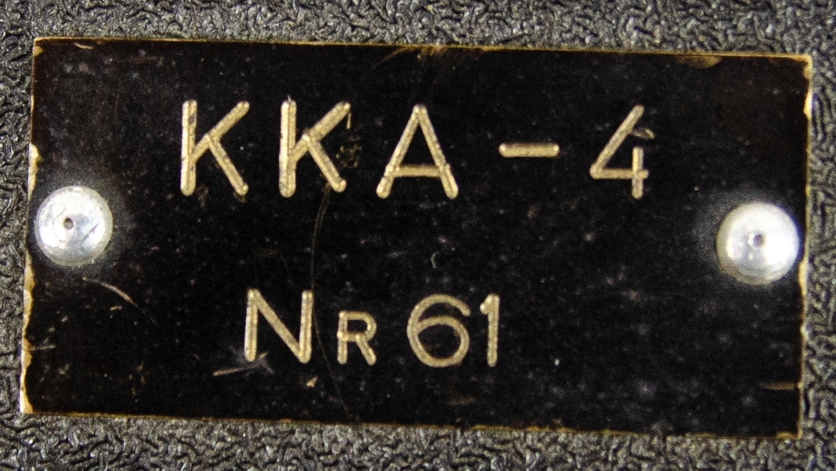 Kulsprutekamera KKA-4. Svart låda av metall och glas, med fäste. Tillverkad av The Lackner Company Inc. Cincinnati, Ohio, USA.