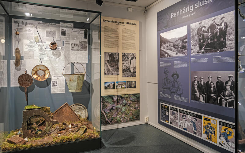 Bildet viser området om Dynamittangrepet i Hakavik og Renhårig Slusk i Utstillingsbygget på Norsk fjellsprengningsmuseum, med tekstplaner og historiske gjennstander.