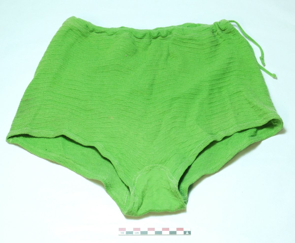Grønn badedrakt (bikini) i to delar, sydd i grønt stoff og grønne band. Bikinitopp (a) og badebukse (b)