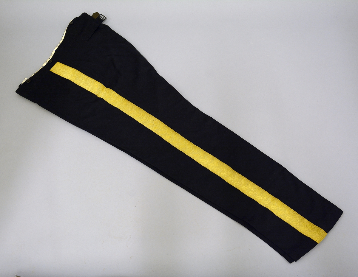 Uniformsbukse. Nr. 111: av svart klæde; gullborde som fyrre nr. (ein rank av eikeblad og eikekonglar/eikenøtar).Fra protokoll. Uniformsbuksen tilhører livkjole TGM-BM:095.